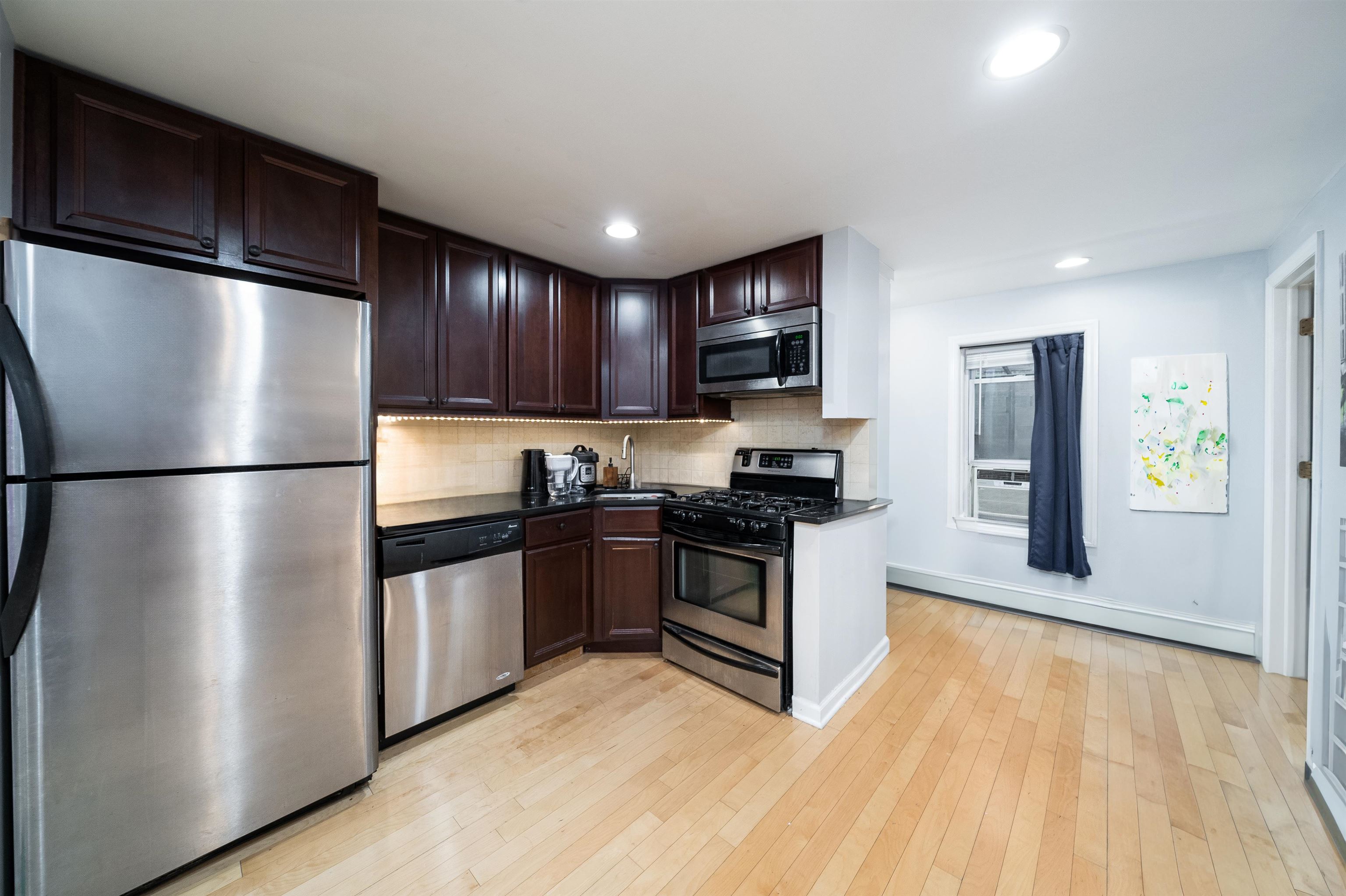 a kitchen with stainless steel appliances granite countertop a refrigerator and a stove top oven