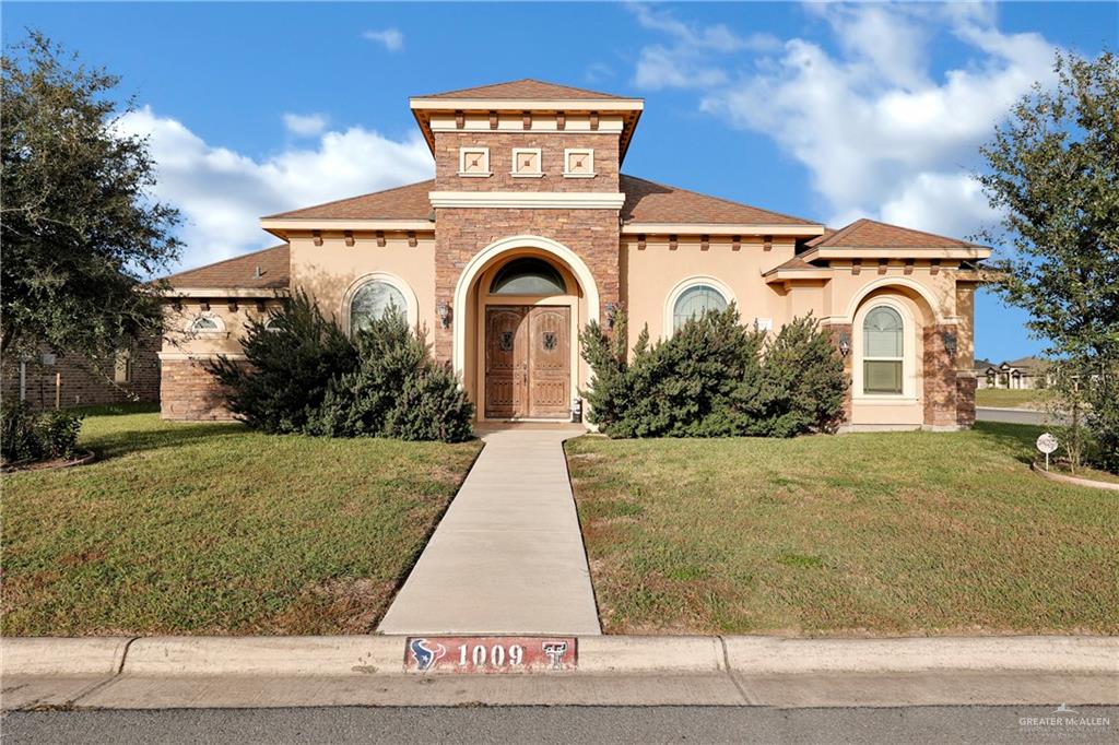 Mediterranean / spanish house with a front lawn