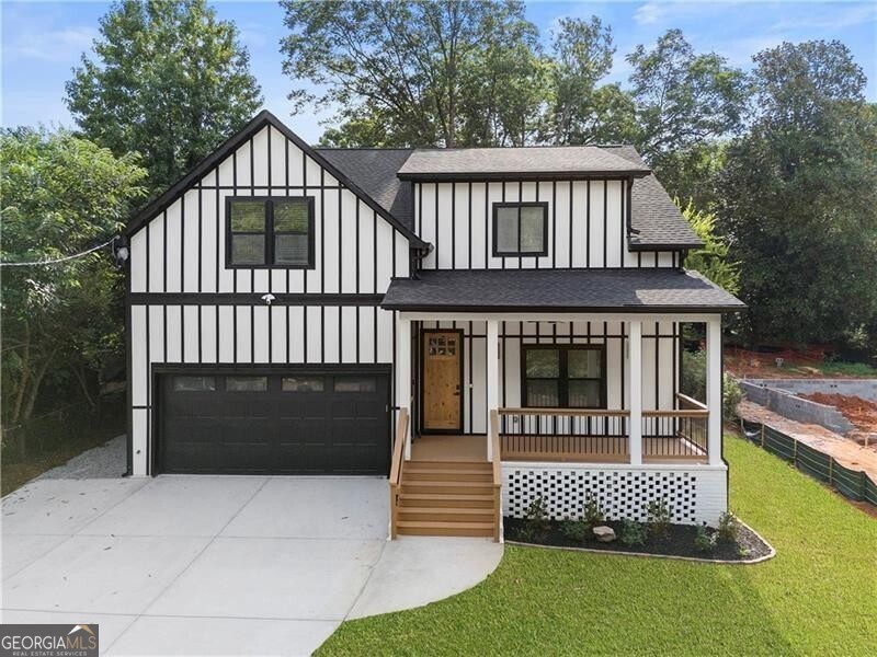 Tudor house with a garage, a porch, and a front yard