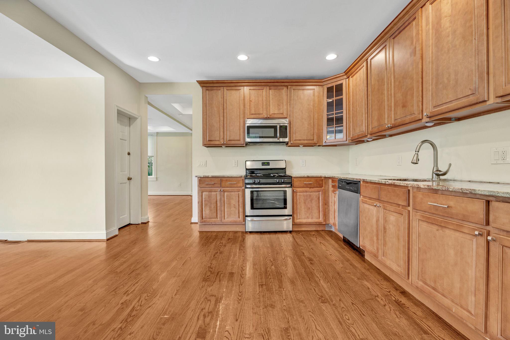 a kitchen with stainless steel appliances granite countertop a stove a sink and a refrigerator