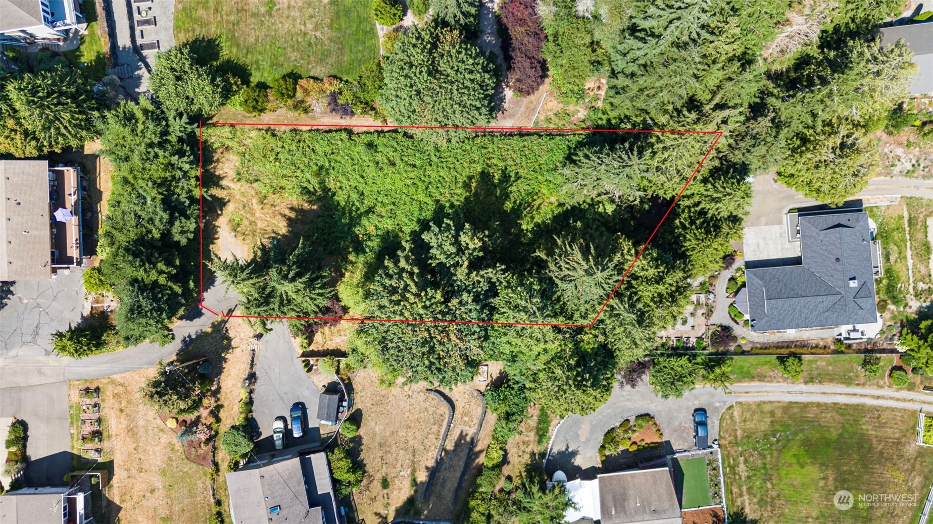 an aerial view of residential house with outdoor space and trees all around