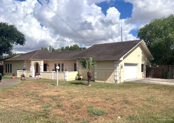 Ranch-style home with a garage and a front yard