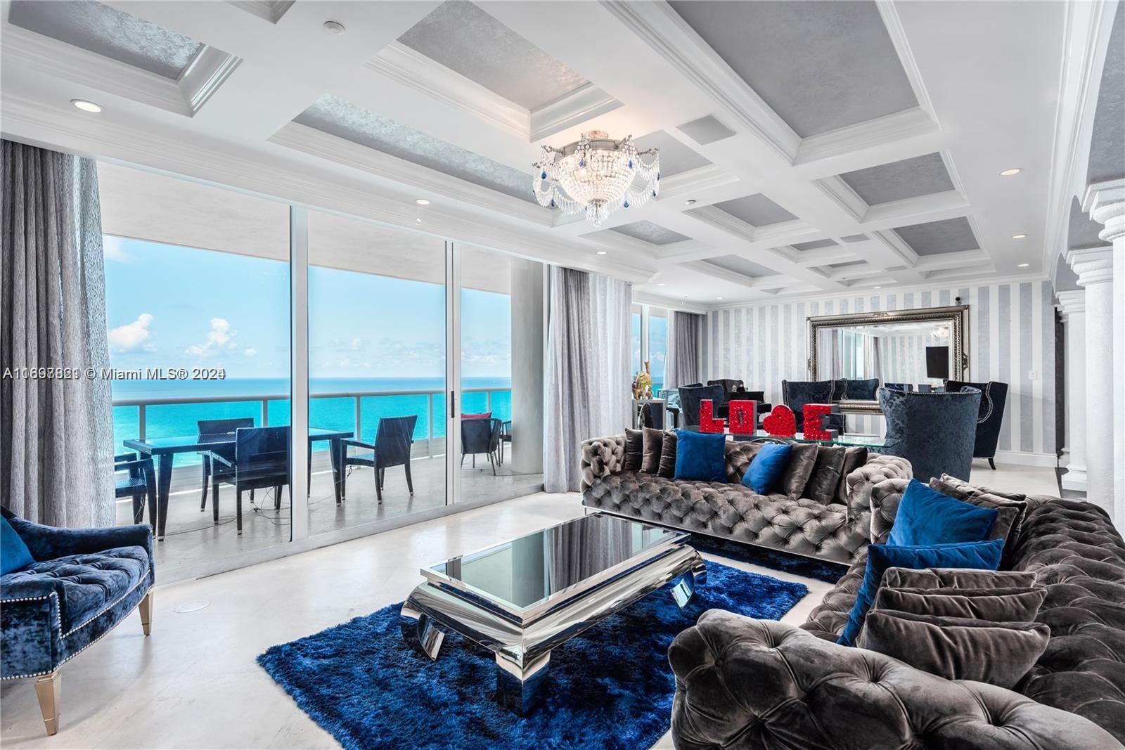 a living room with furniture a chandelier and a large window