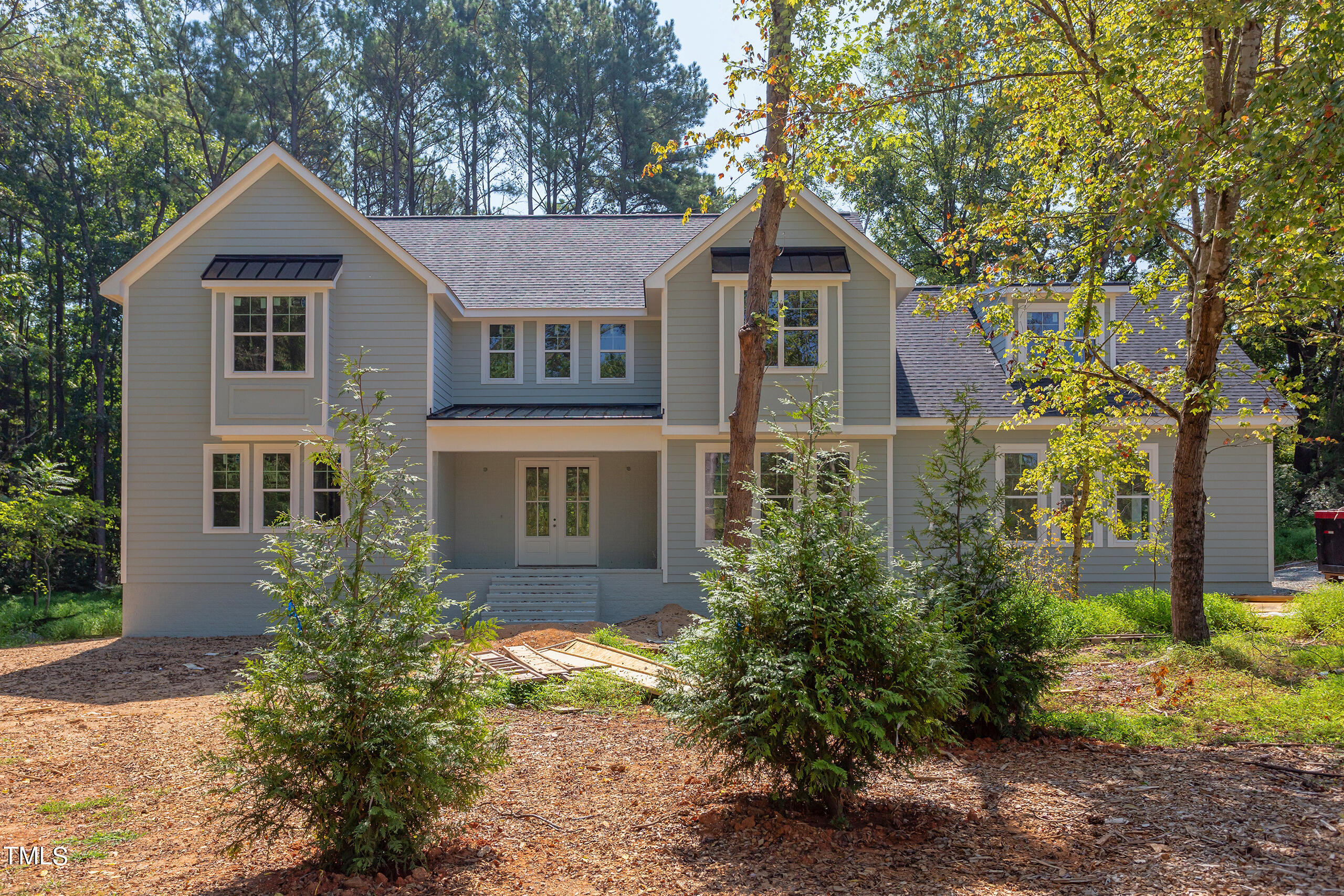 a front view of a house with a yard and trees