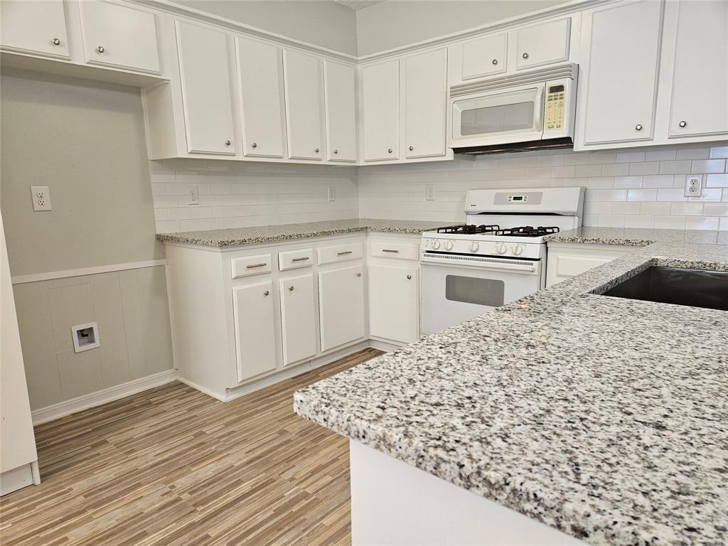 a kitchen with white cabinets and sink