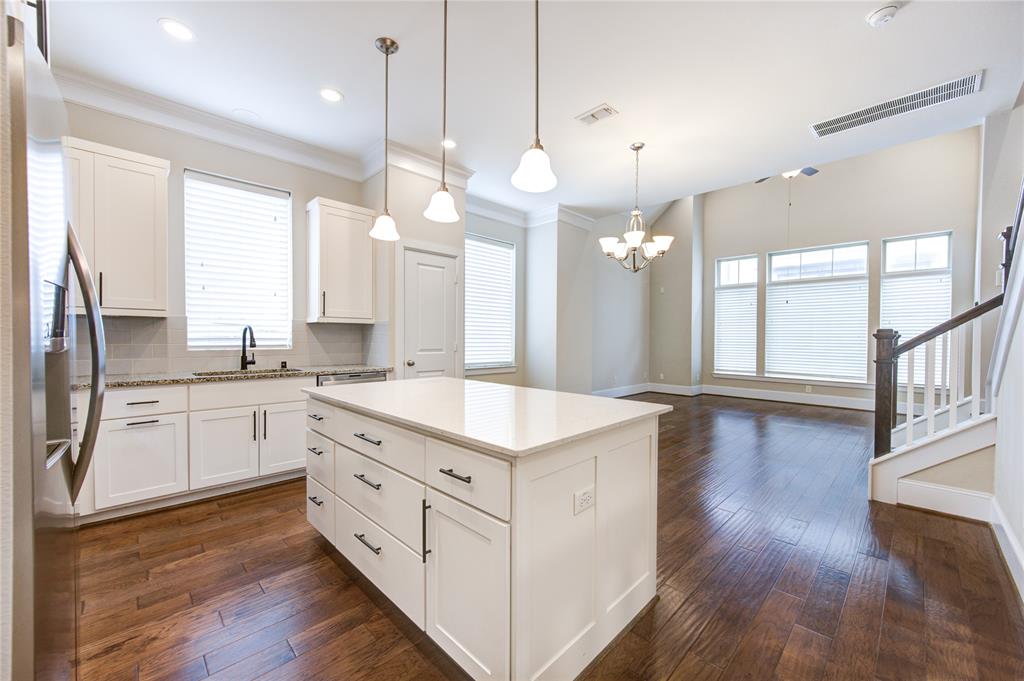 a kitchen with a stove a sink and a wooden floor