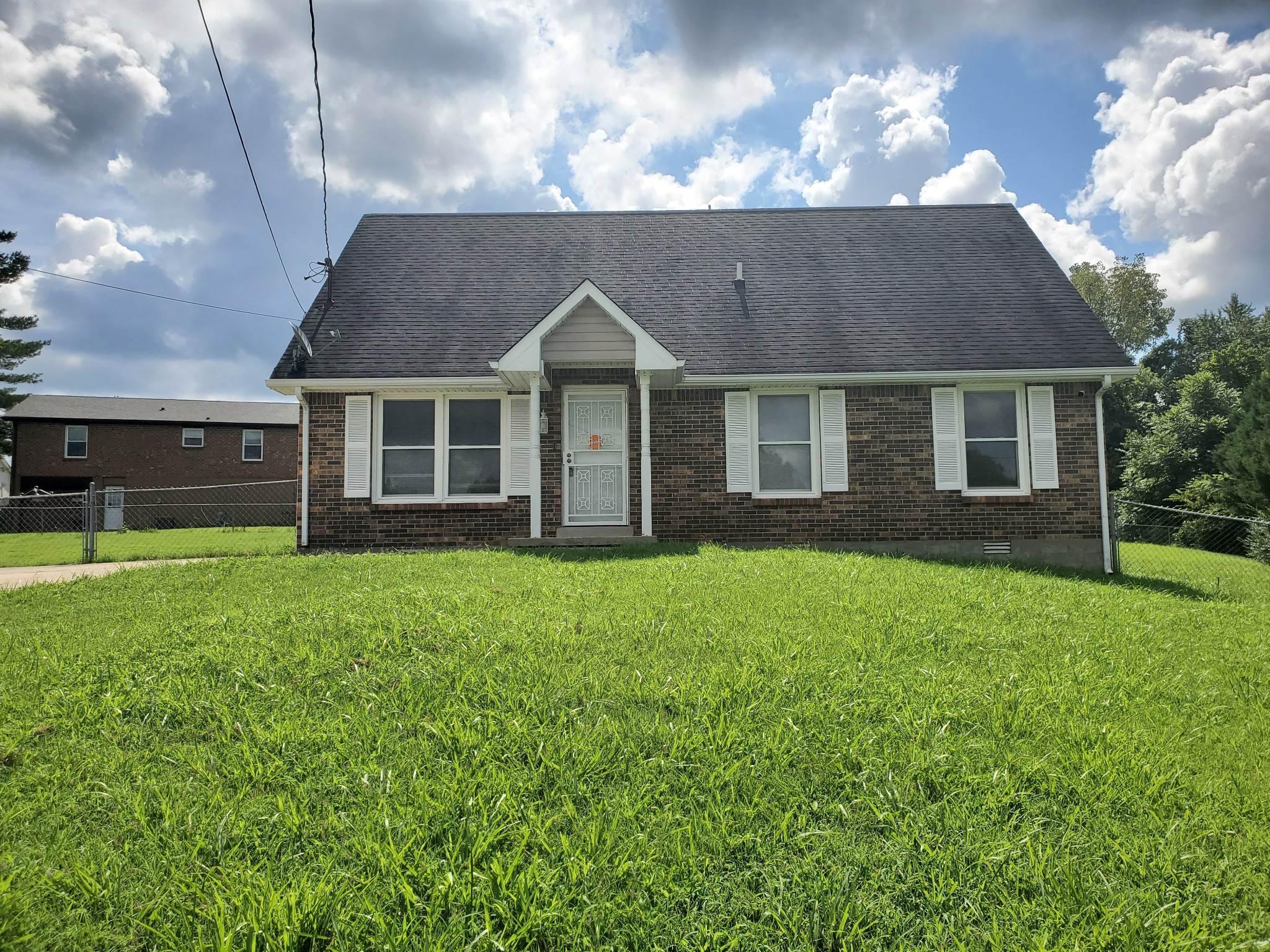 a front view of house with yard and green space