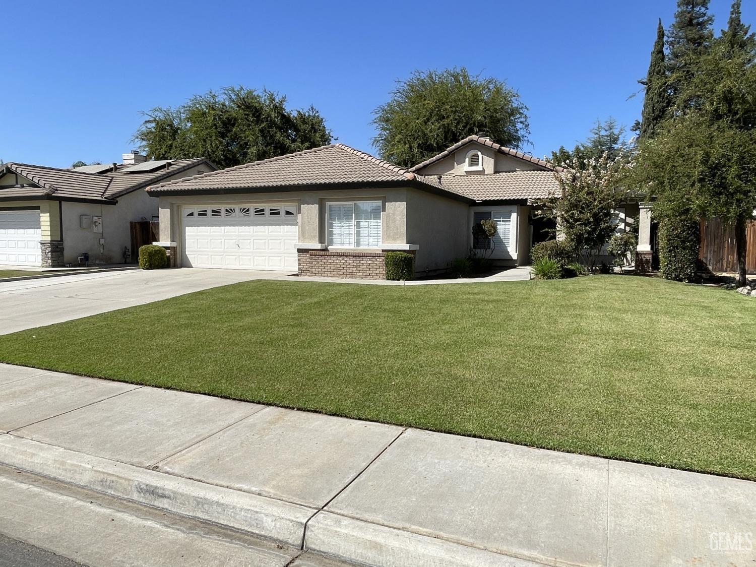 a front view of a house with a garden and yard