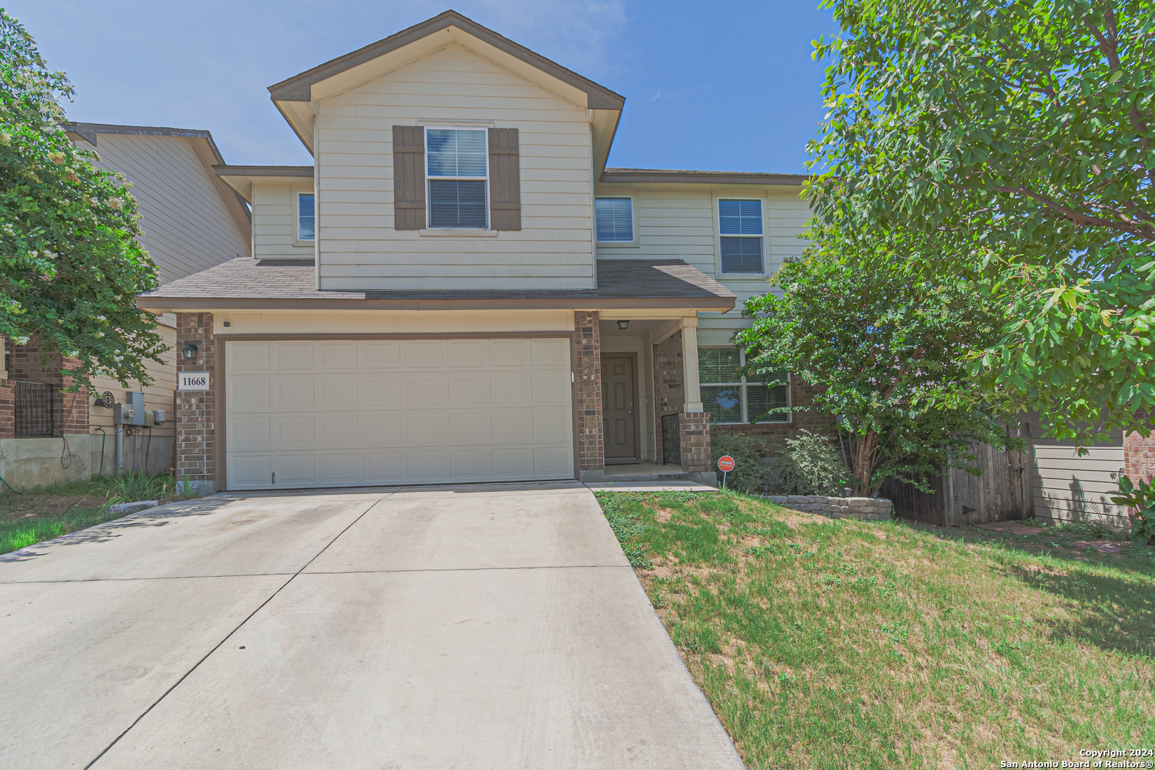 a front view of a house with a yard and a garage