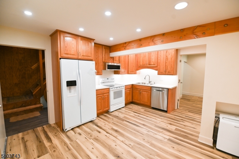 a kitchen with a sink a refrigerator a counter top space and cabinets