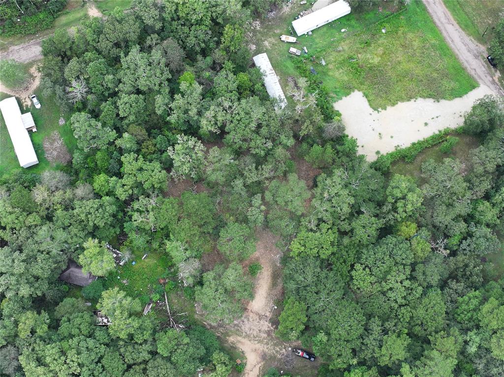 an aerial view of residential houses with outdoor space and trees all around