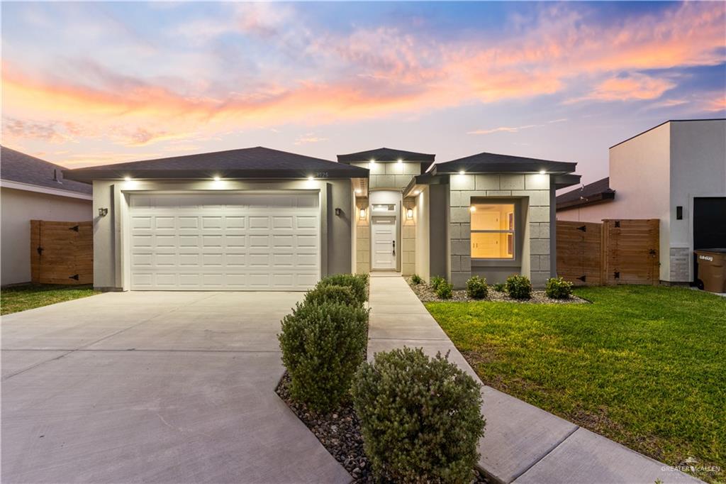 View of front of house with a lawn and a garage