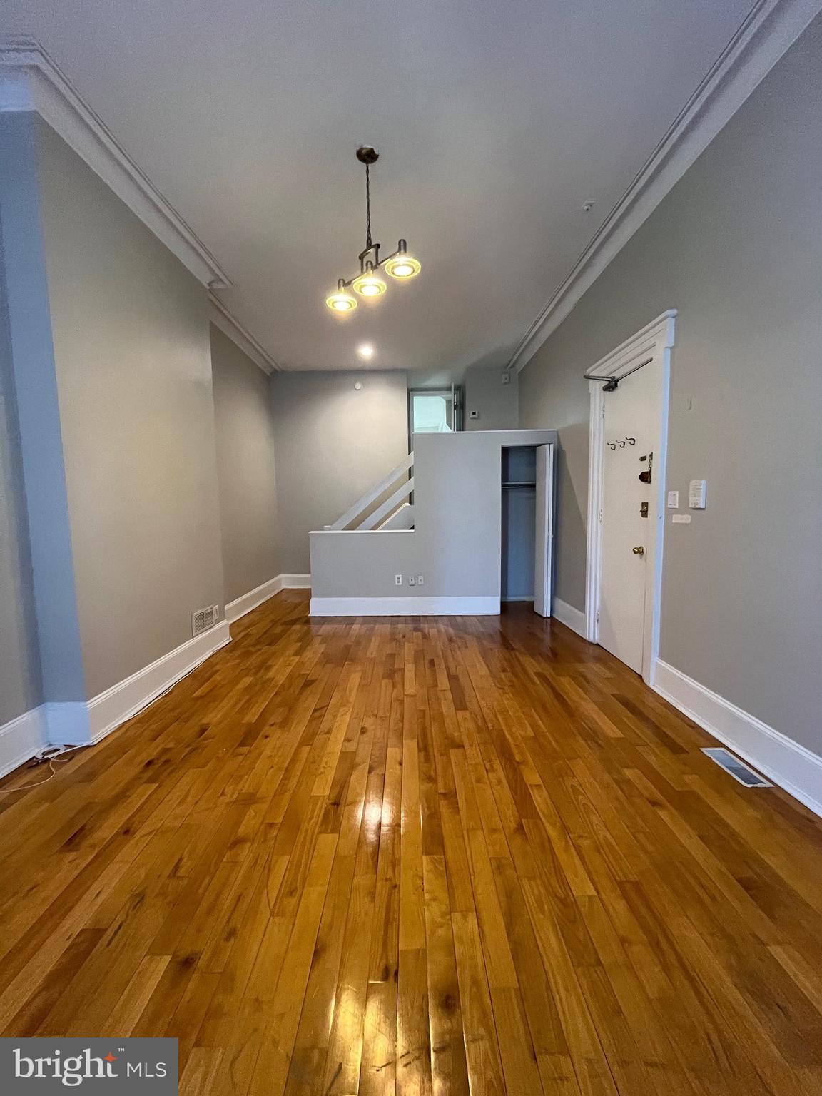 a view of empty room with wooden floor