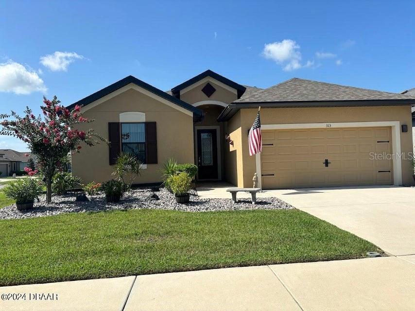 a front view of a house with a yard and garage