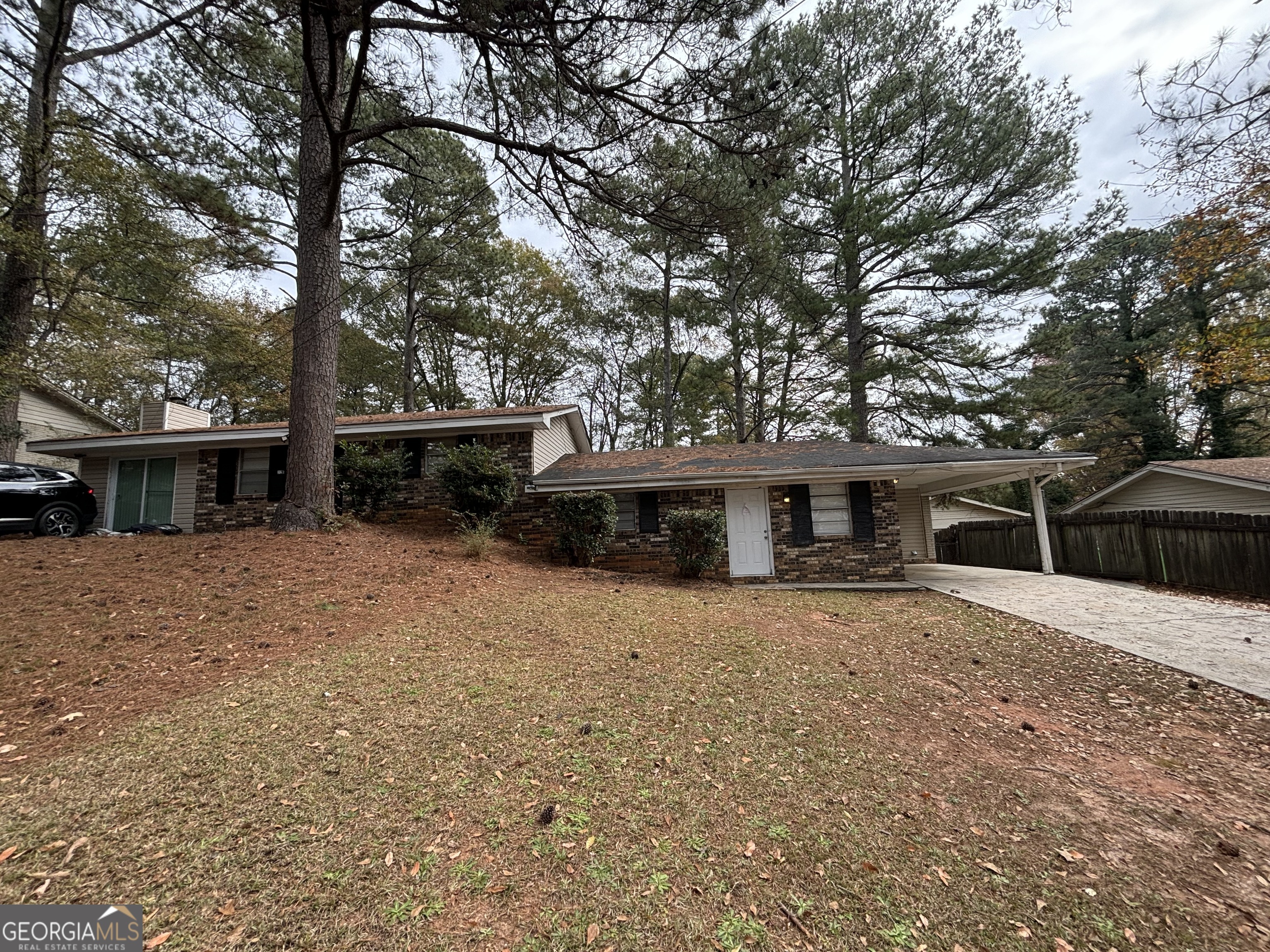 a front view of house with yard and trees in the background