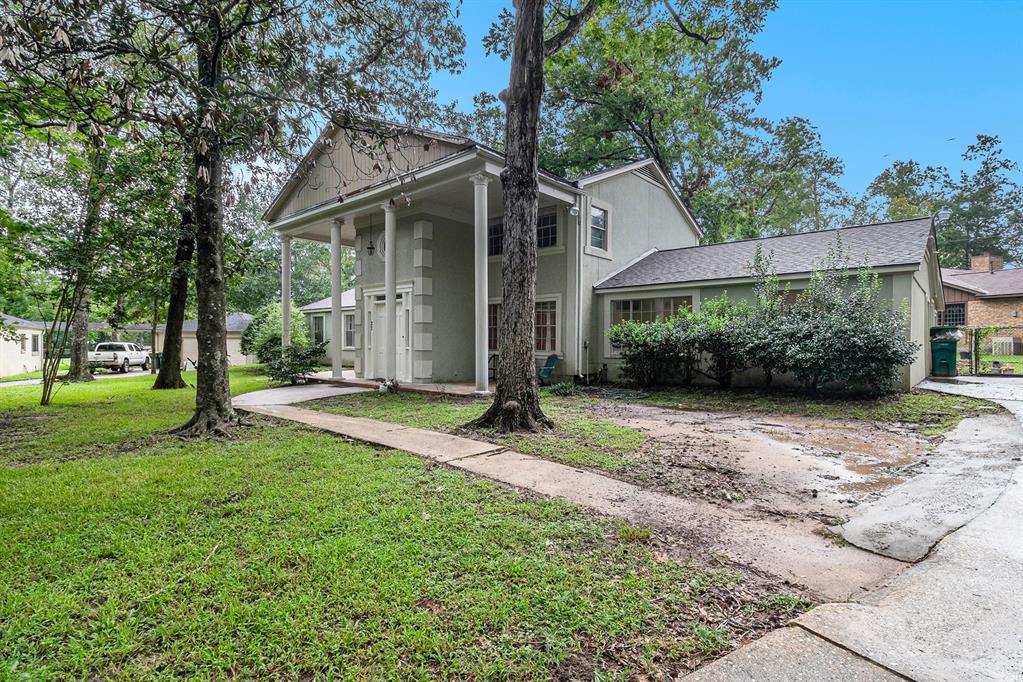 a view of a house with backyard and a tree