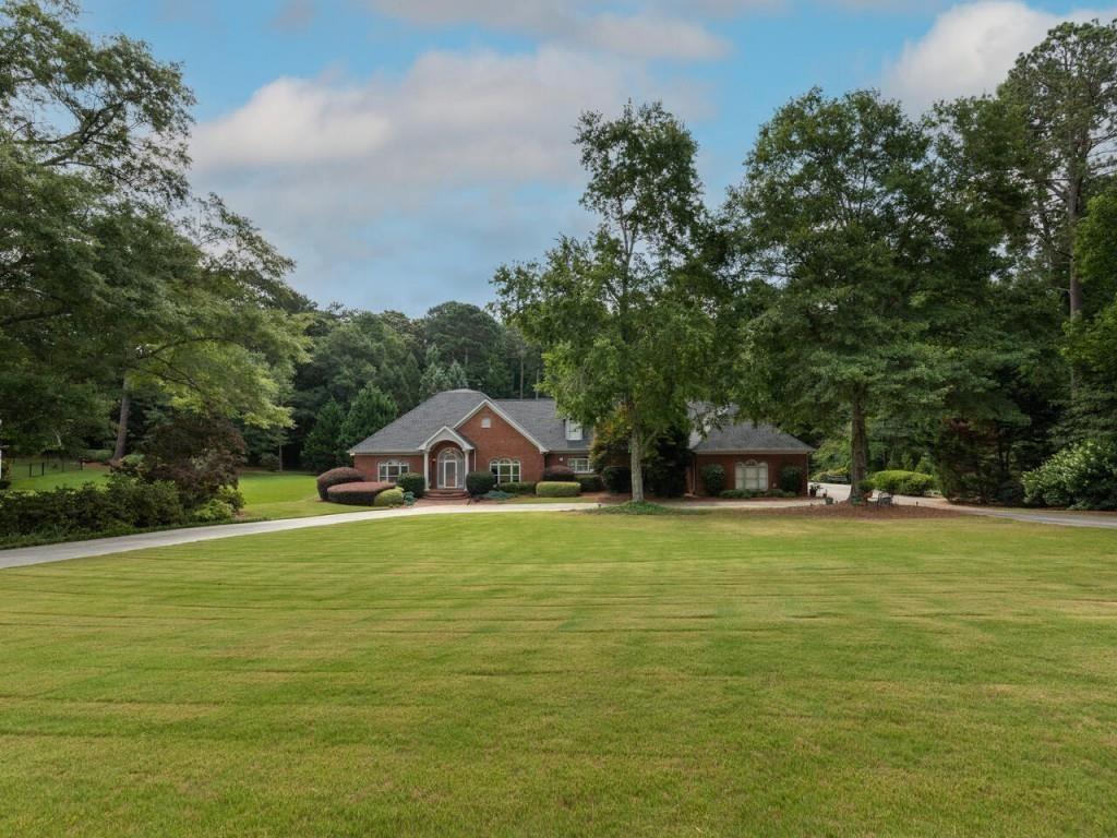 a front view of a house with a yard and trees