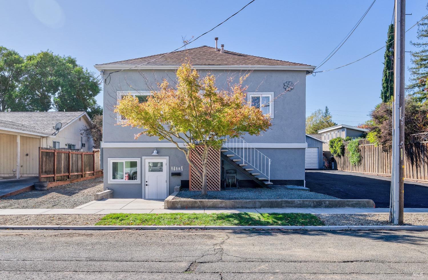 a front view of a house with a yard and potted plants