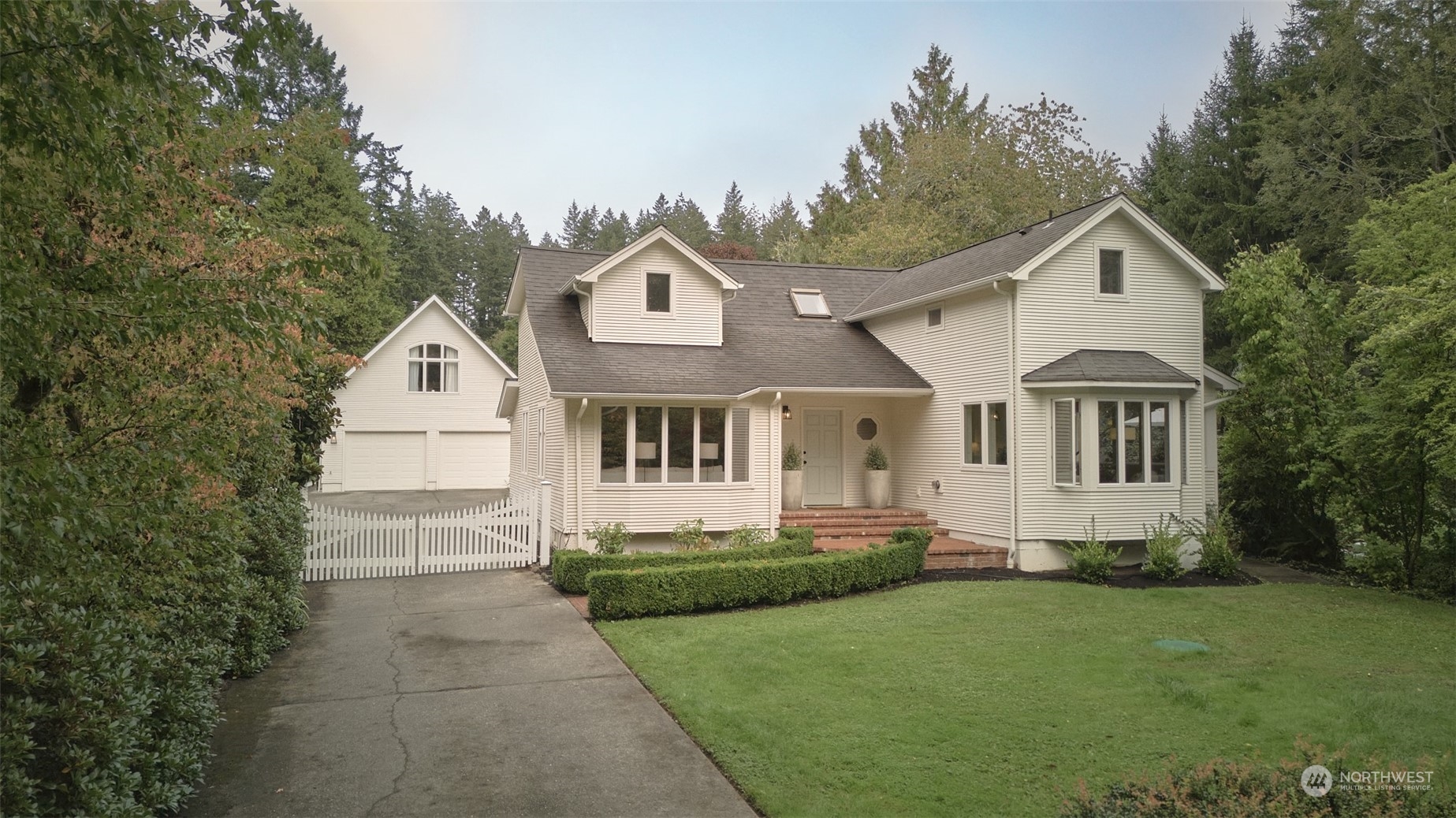 a front view of a house with a yard and trees