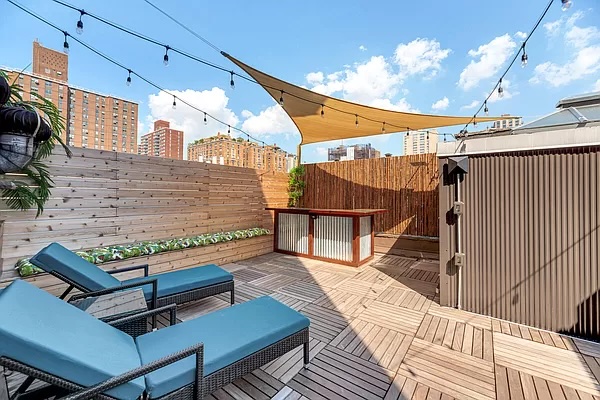 a roof deck with table and chairs