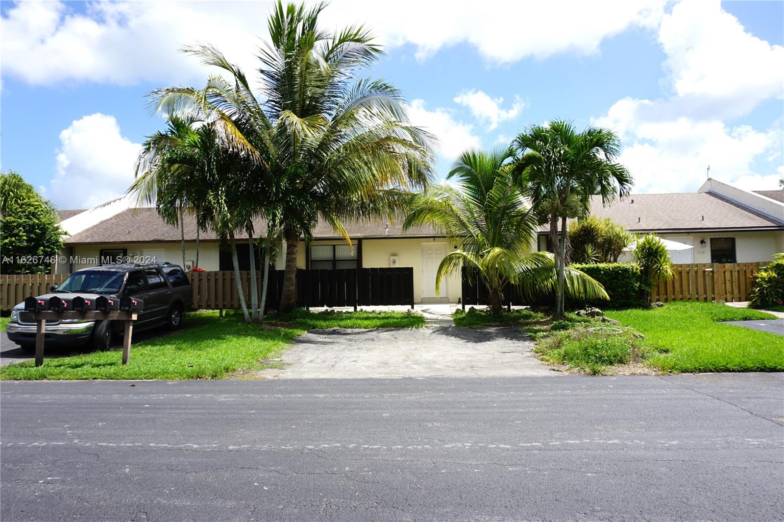 a view of a house with a yard and large trees