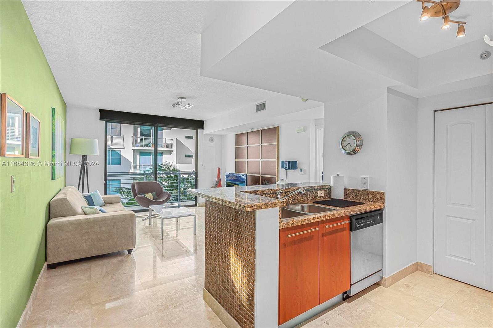 a view of kitchen with stainless steel appliances granite countertop stove top oven and couches