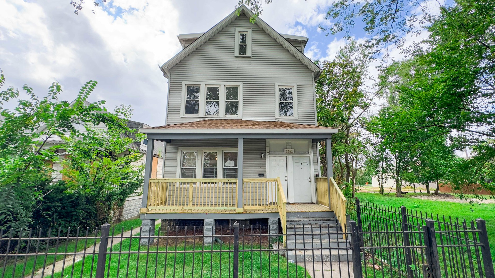 a front view of a house with a yard and potted plants