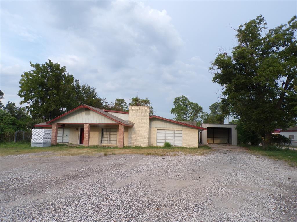 a view of a house with a yard and large tree