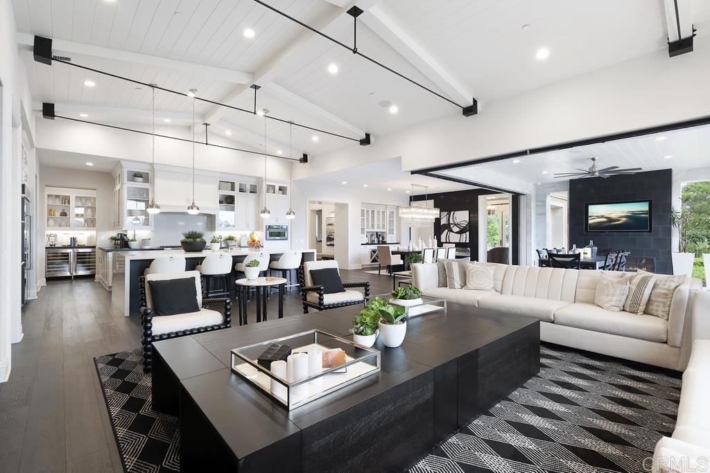 a living room with lots of furniture and view of kitchen