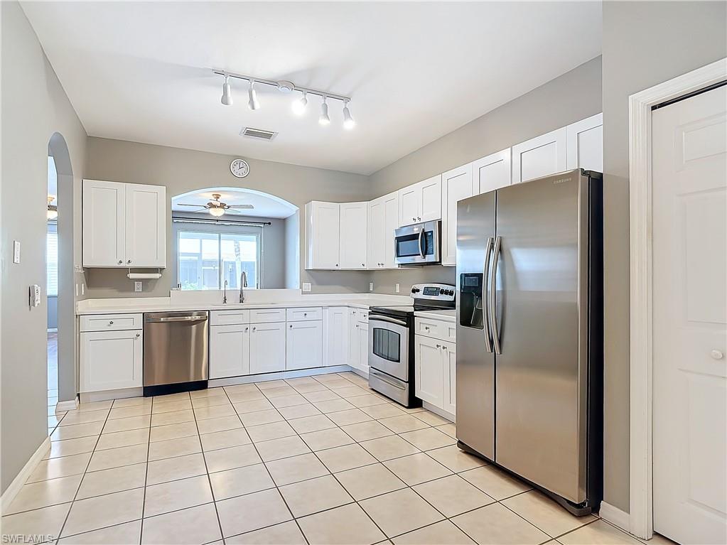 a kitchen with a refrigerator sink cabinets and microwave