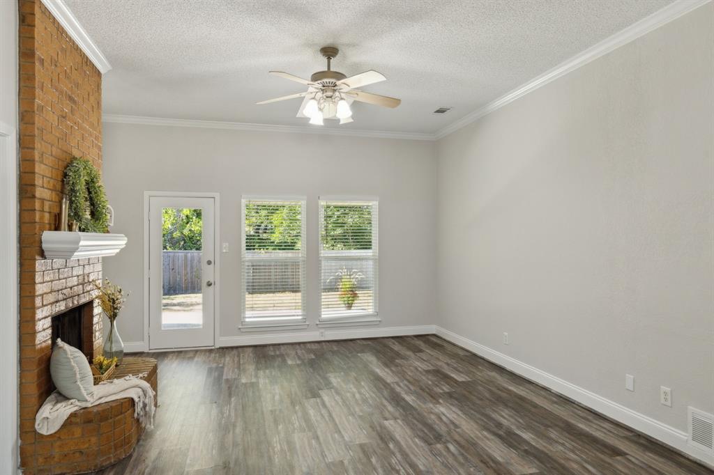 a view of an empty room with a fireplace and a window