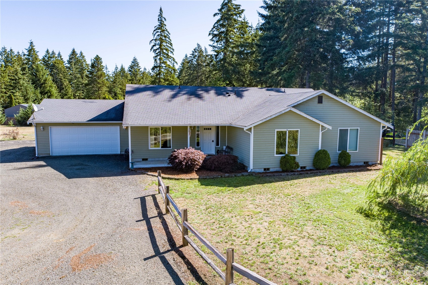 a front view of house with yard and trees in the background