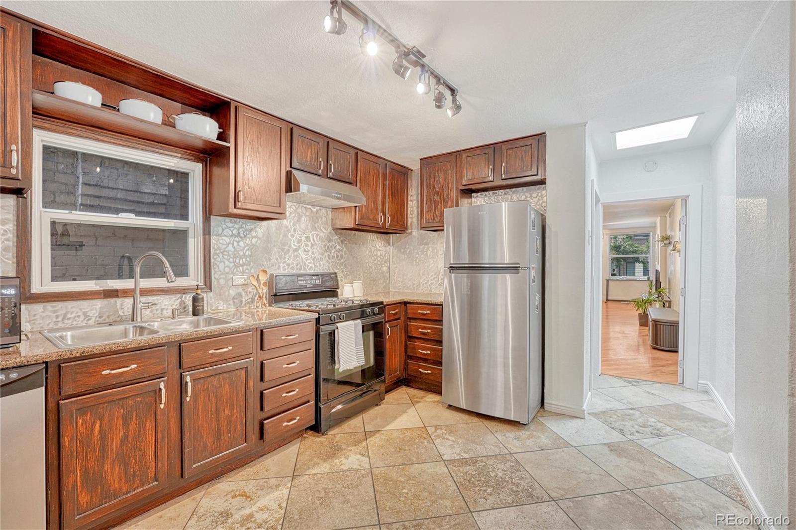 a kitchen with stainless steel appliances granite countertop a refrigerator and a sink