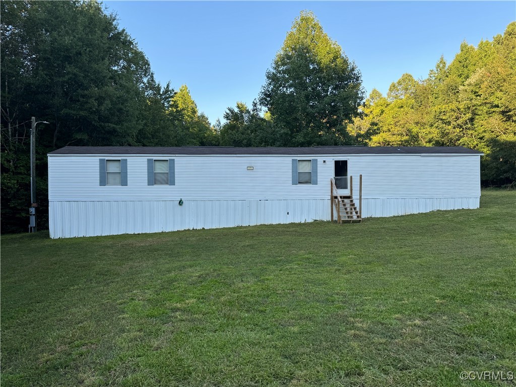 a front view of house with yard and trees in the background