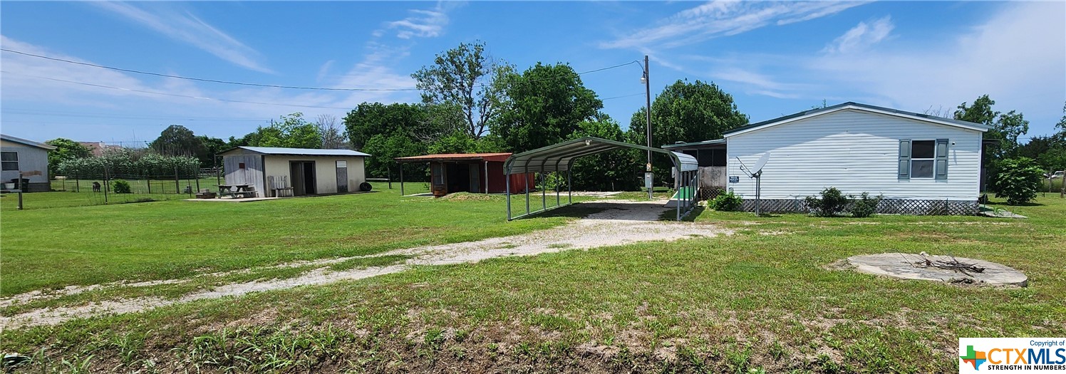 a view of a house with backyard and a tree