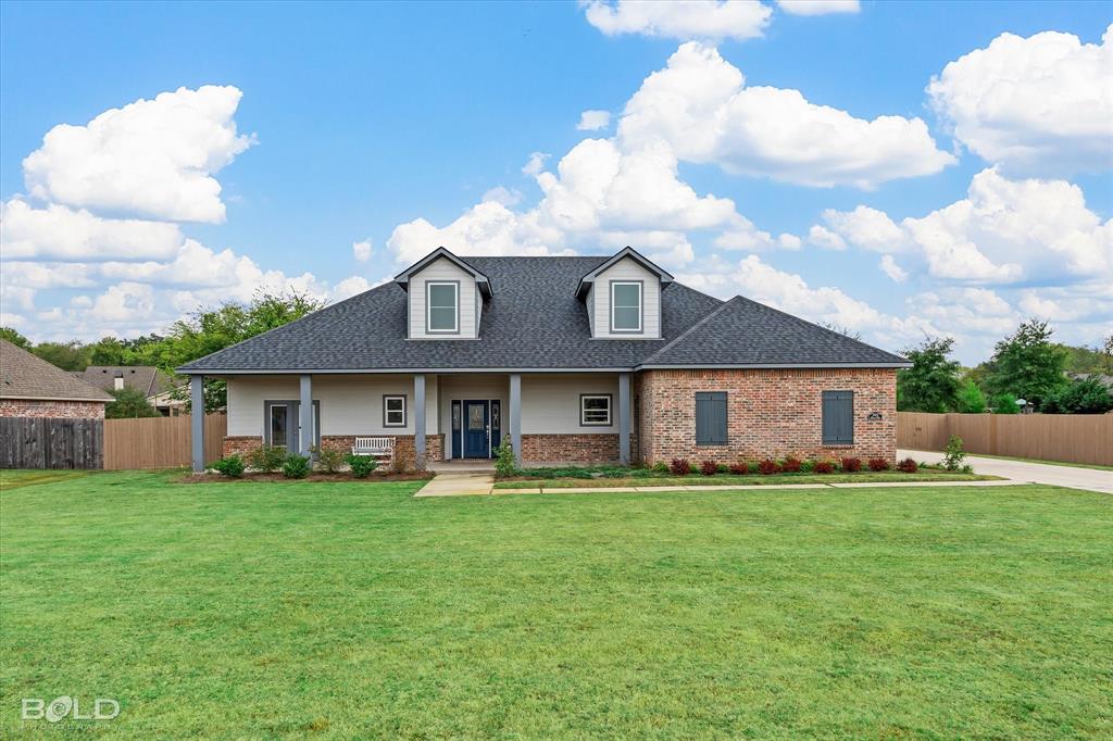 a view of a house with a yard and sitting area