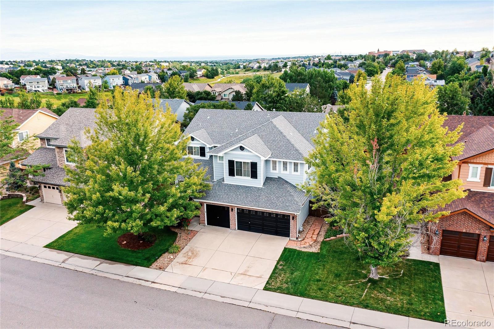 an aerial view of a house with a yard and large trees