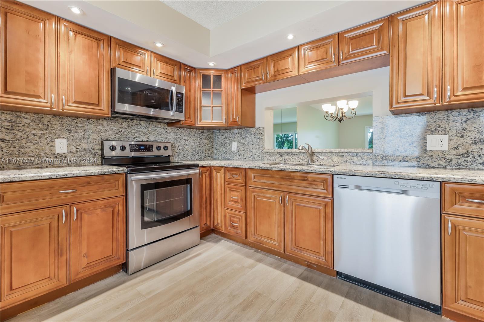 a kitchen with stainless steel appliances granite countertop a stove a sink dishwasher and microwave oven with cabinets