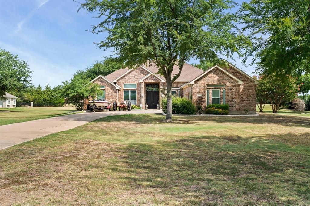 a front view of a house with a yard and trees