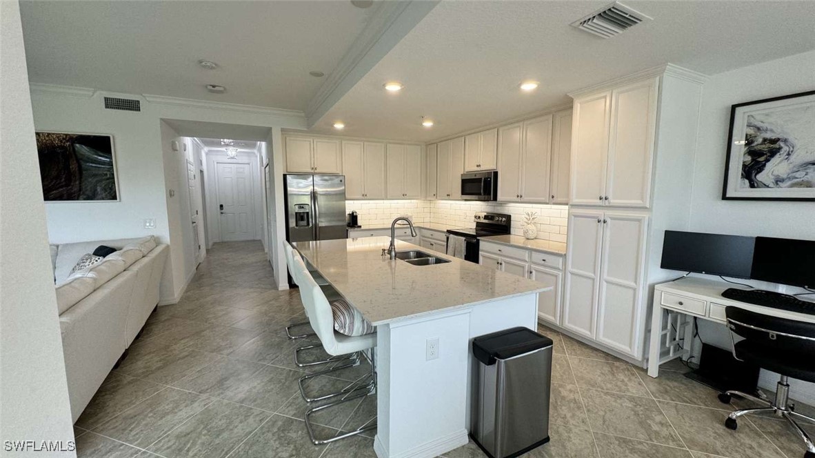 a kitchen with kitchen island a stove a sink and a refrigerator