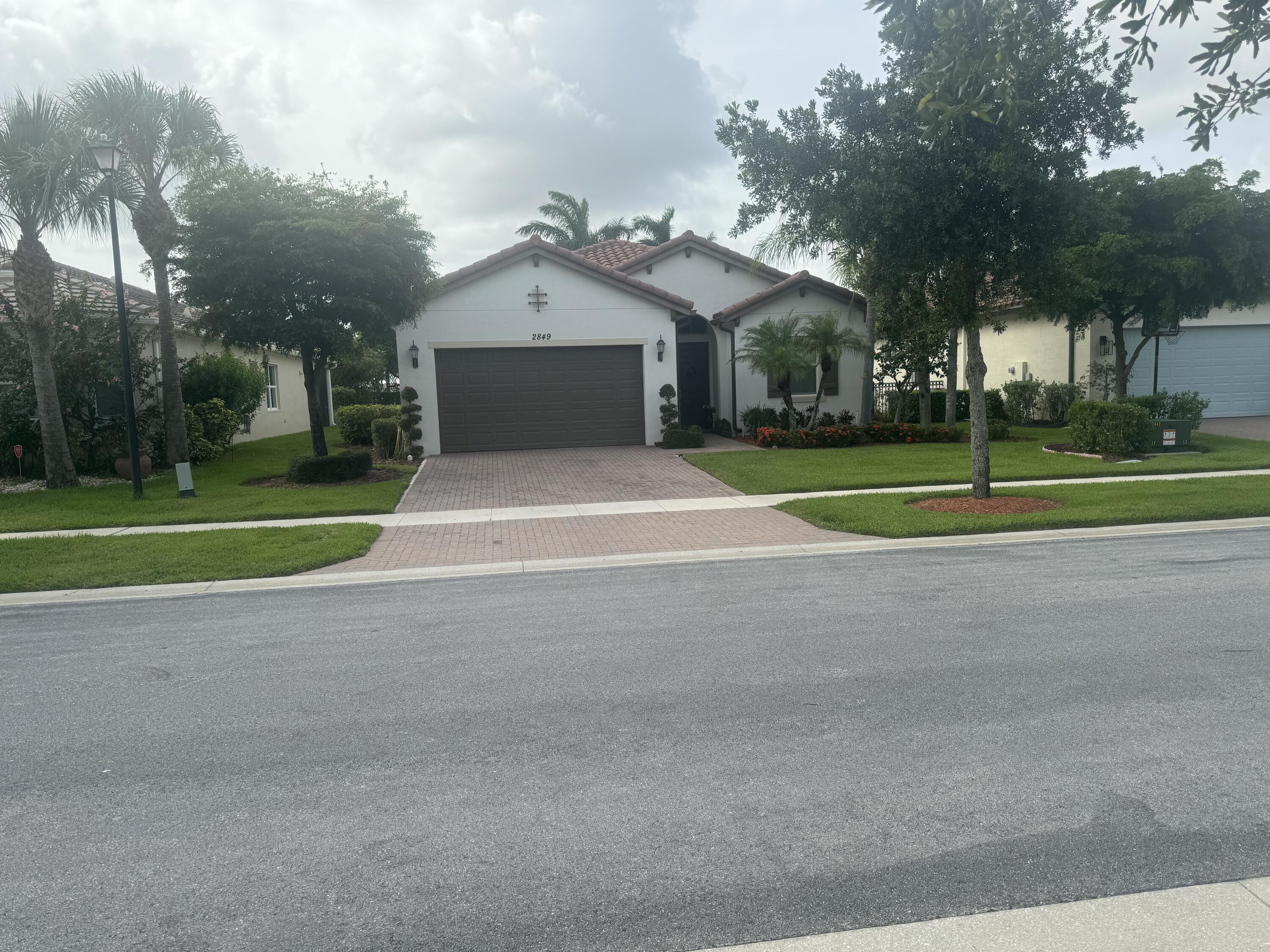 a view of a house with a yard and large trees