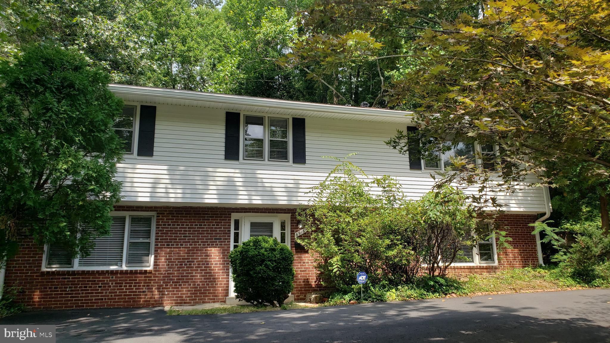 a front view of a house with a tree