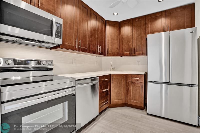 a kitchen with stainless steel appliances a refrigerator stove and microwave