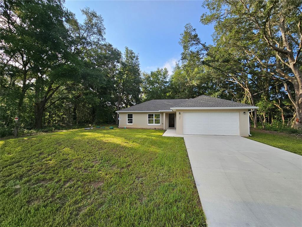 a front view of house with yard and trees