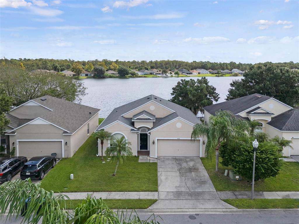 a aerial view of a house with a yard and a large tree