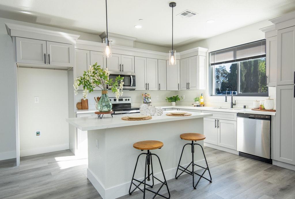 a kitchen with stainless steel appliances a table and chairs in it