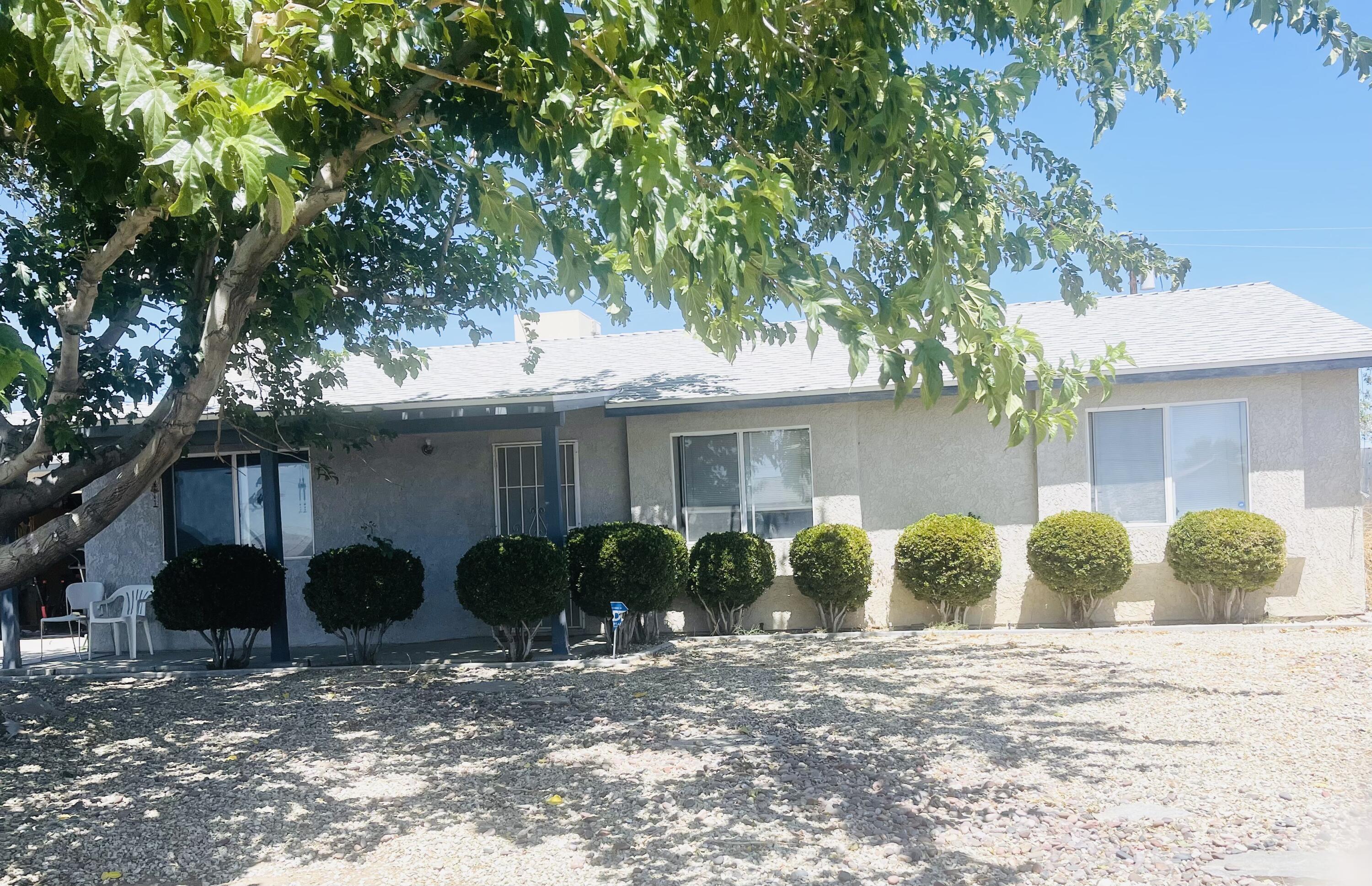 a view of a house with backyard and a tree