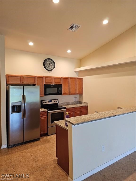 a kitchen with stainless steel appliances granite countertop a refrigerator a stove and a sink