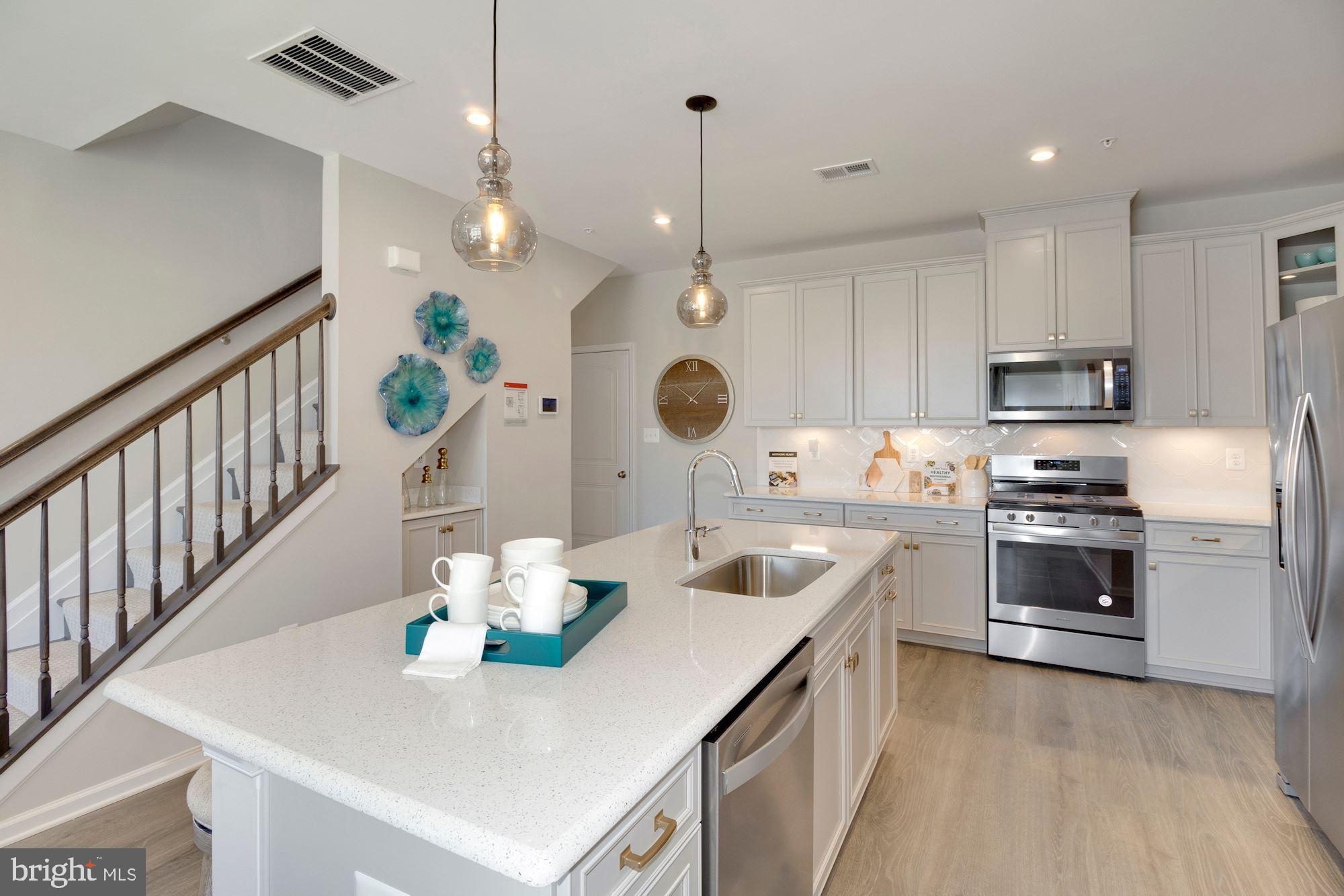 a kitchen with white cabinets stainless steel appliances and kitchen view