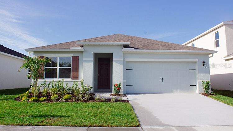 a front view of a house with a yard and potted plants